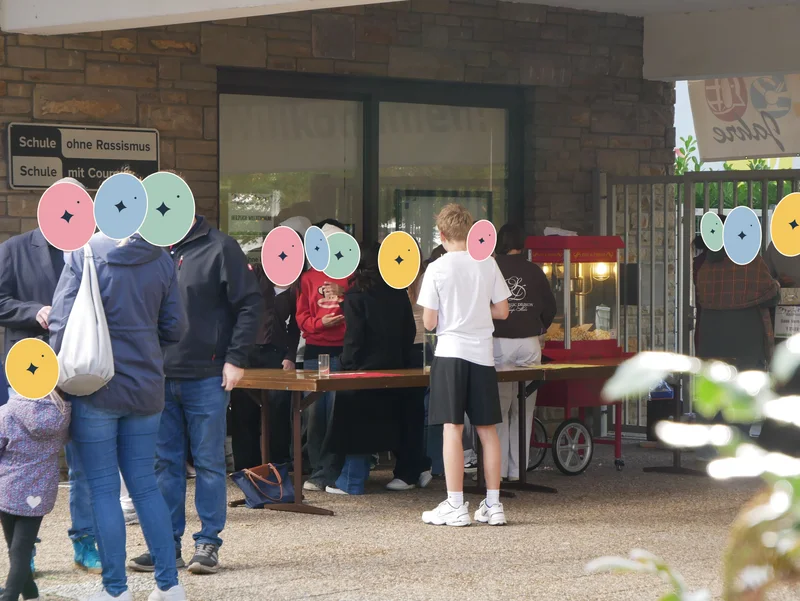 Gäste und Helferinnen und Helfer an der Popcornmaschine am Haupttor.