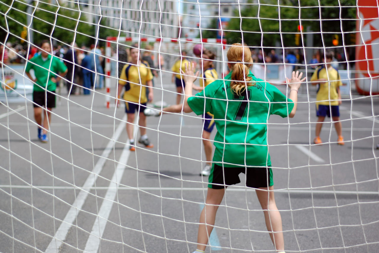 Blick durchs Tornetz auf ein Handballspiel